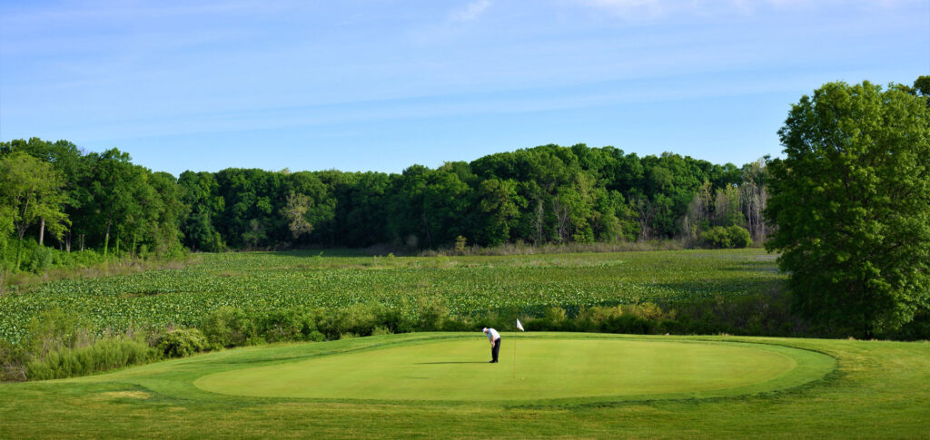 A golfer putts at the green at Elbel Golf Course